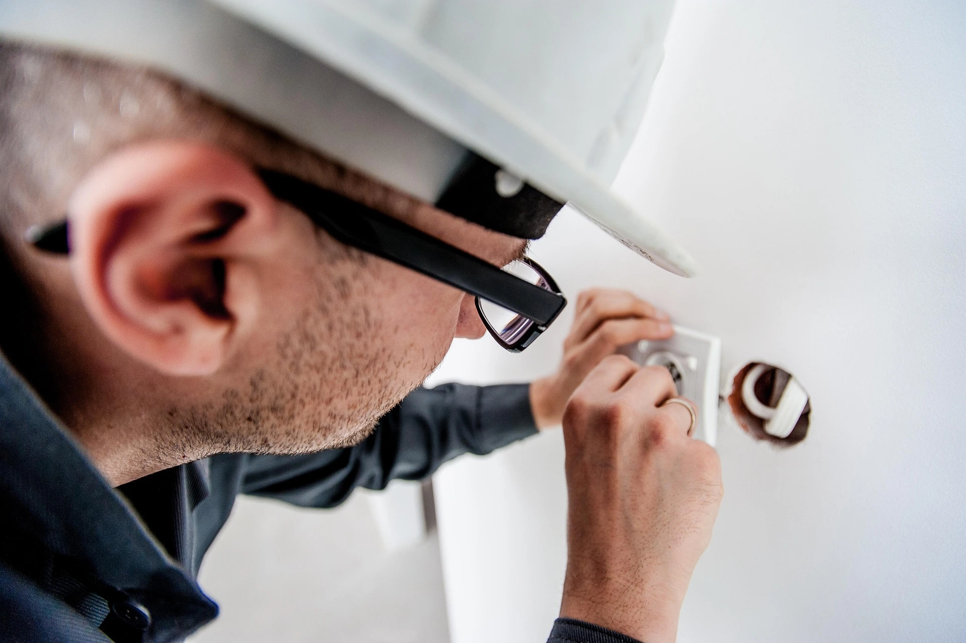 HVAC technician installing a thermostat on an interior wall during a professional home comfort system upgrade