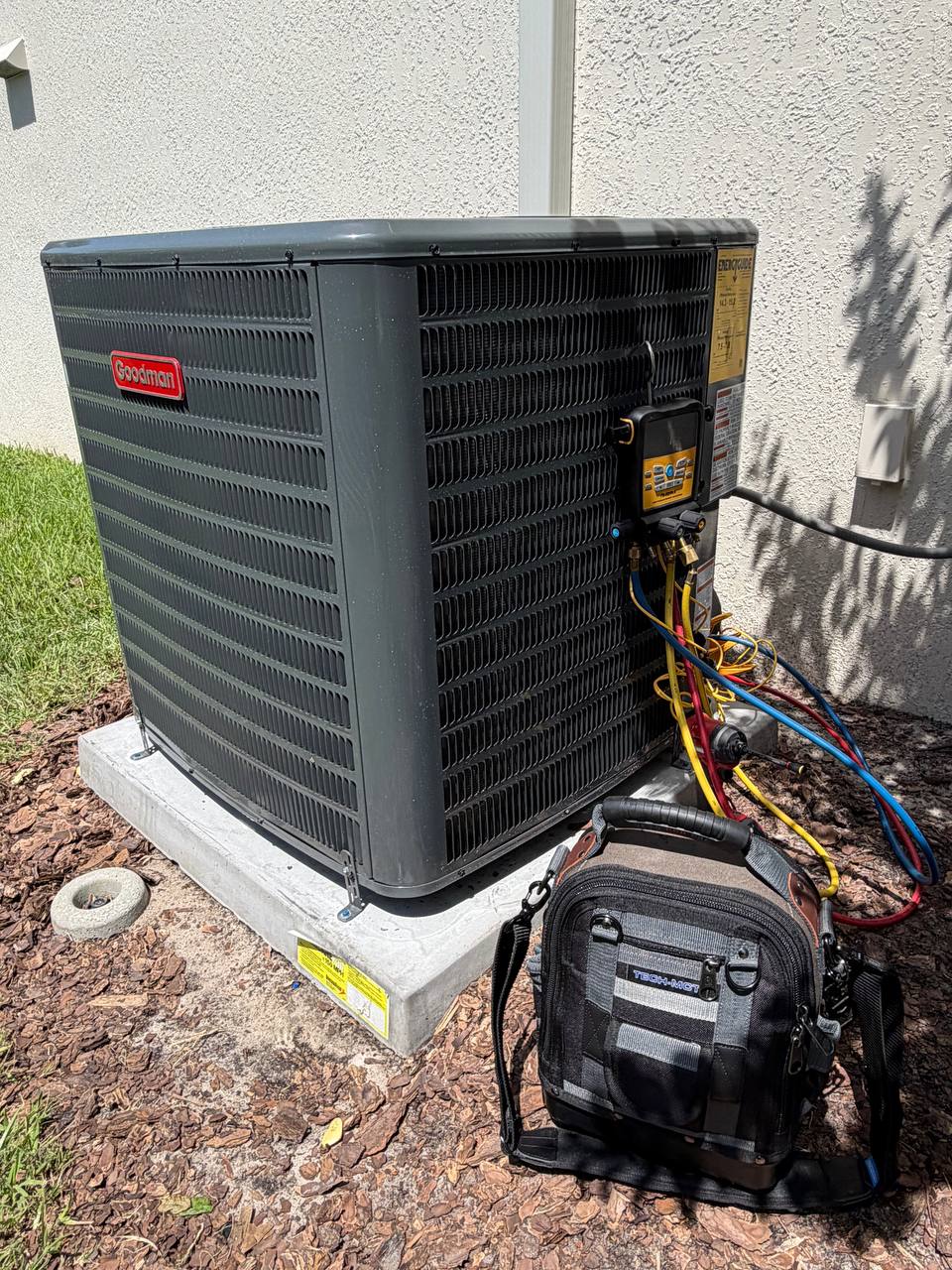Wingman HVAC technician checking an outdoor AC unit during service in Central Florida